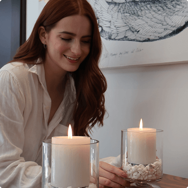 Una mujer pelirroja sonriendo delante de una vela encendida Una mujer pelirroja sonriendo delante de una vela encendida